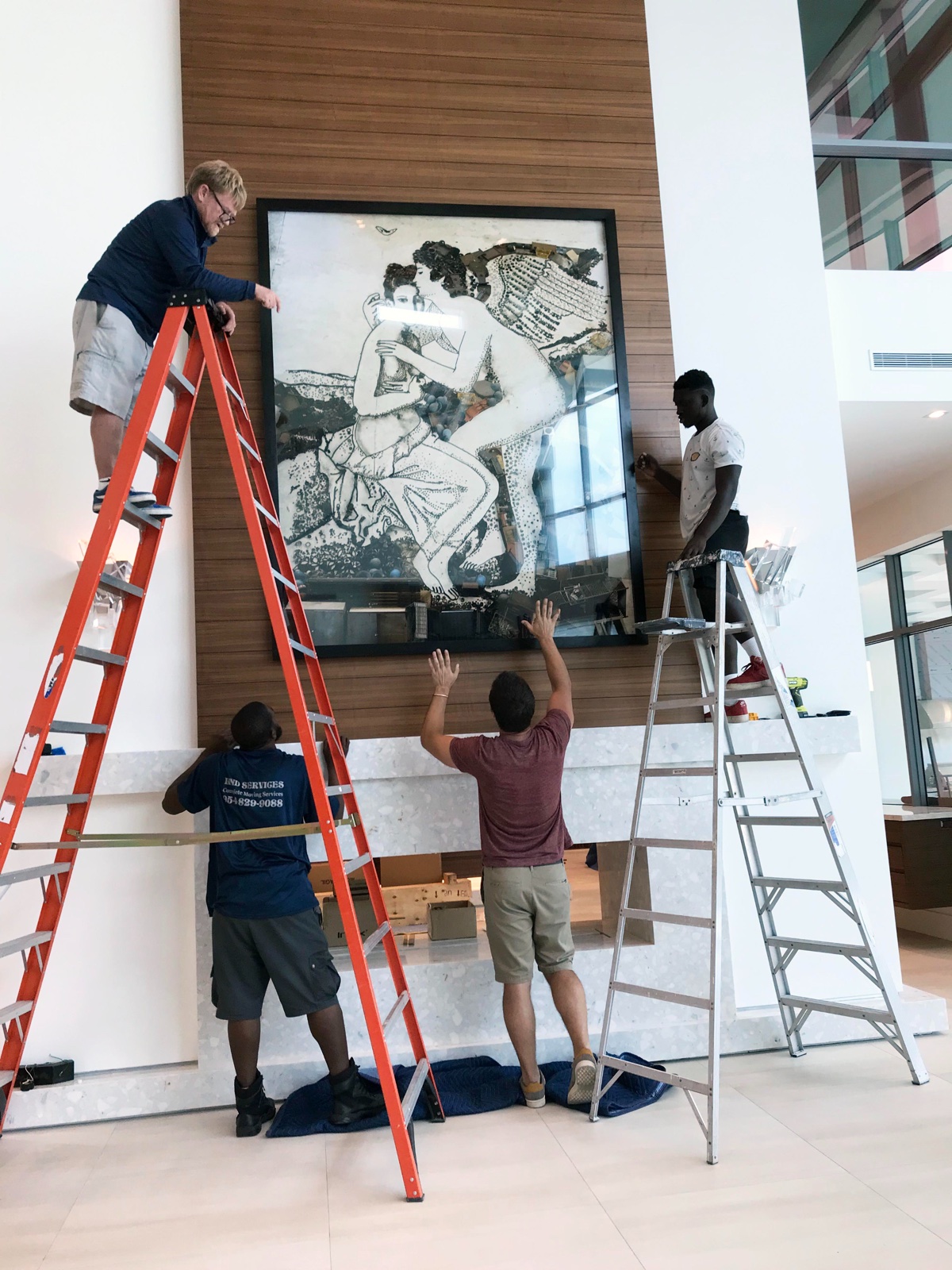 Catalyst Art team installing a large monochrome figurative work